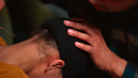 Primer-Plano-De-Un-Padre-Usando-Una-Aguja-Para-Quitarse-El-Pelo-Mientras-Le-Ata-El-Turbante-A-Su-Hijo-Sikh,-Filmado-En-Tiempo-Real